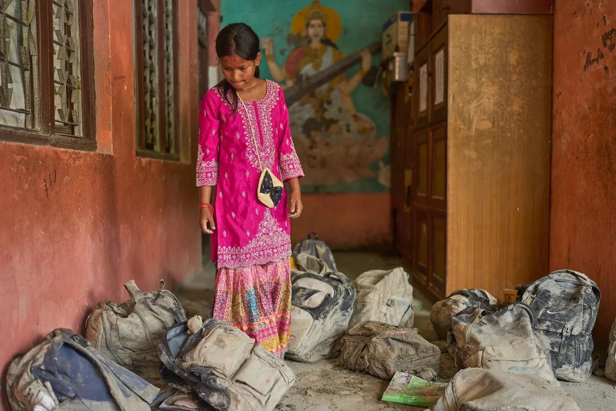 Eine Schülerin sucht nach der schweren Sturzflut in Nepal ihrer Schultasche im Schlamm.